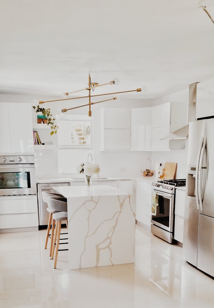 A bright, modern kitchen remodel in San Antonio, TX featuring white cabinetry, stainless steel appliances, and minimalist decor.